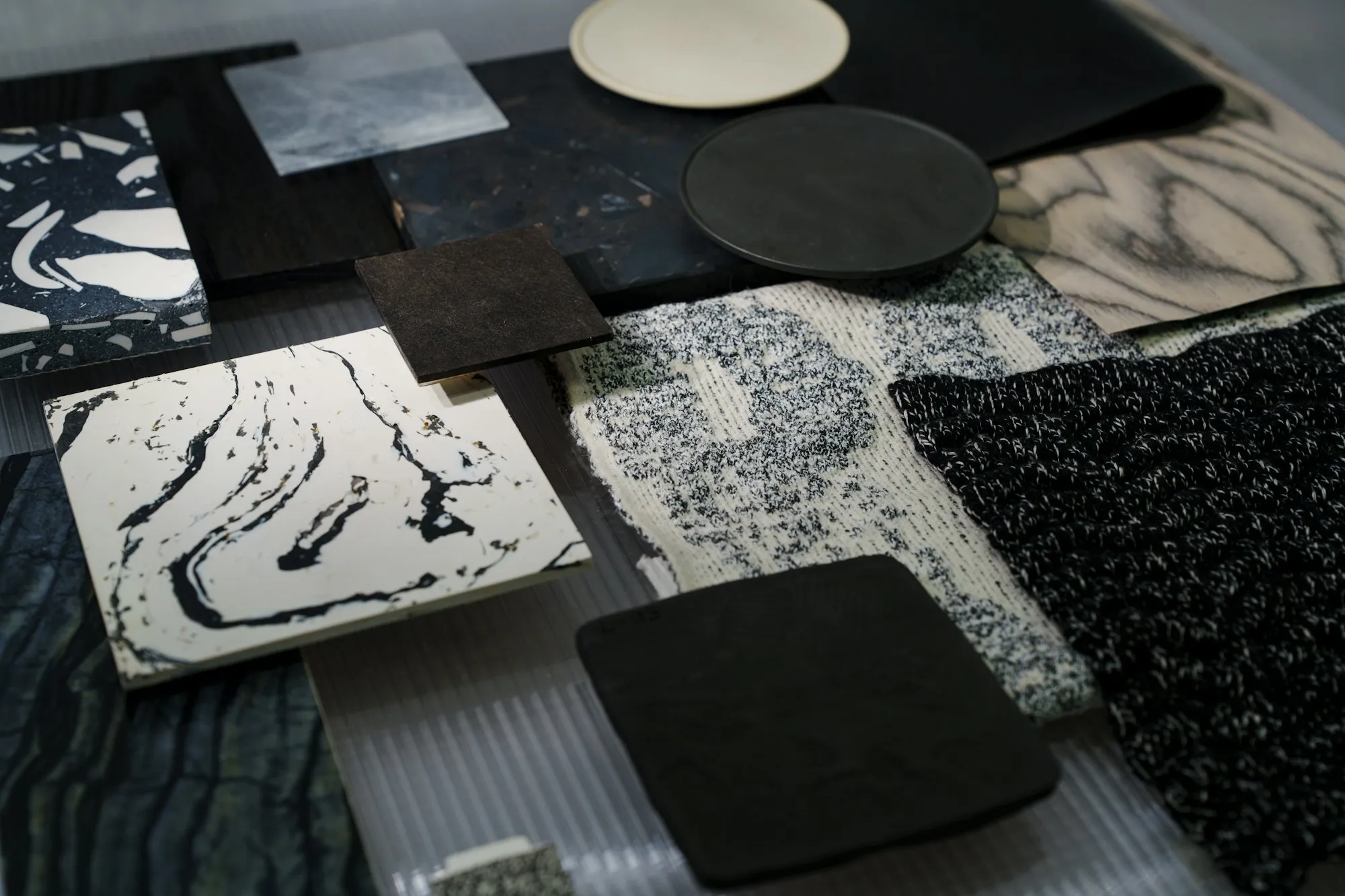 Material samples of stone, fabric and ceramic on a dark table